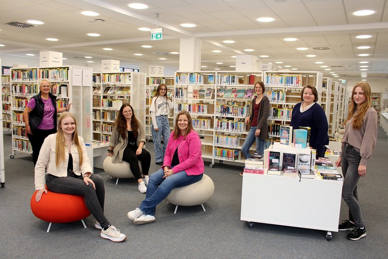 Team der Bücherei vor Regalen