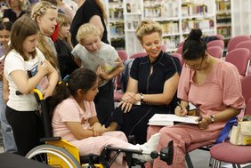 Im Anschluss an die Preisverleihung nahm Ayşe Klinge sich die Zeit, die Bücher der Kinder zu signieren und mit individuellen Comic-Zeichnungen zu versehen. Mit dabei: NRW-Kulturministerin Ina Brandes.